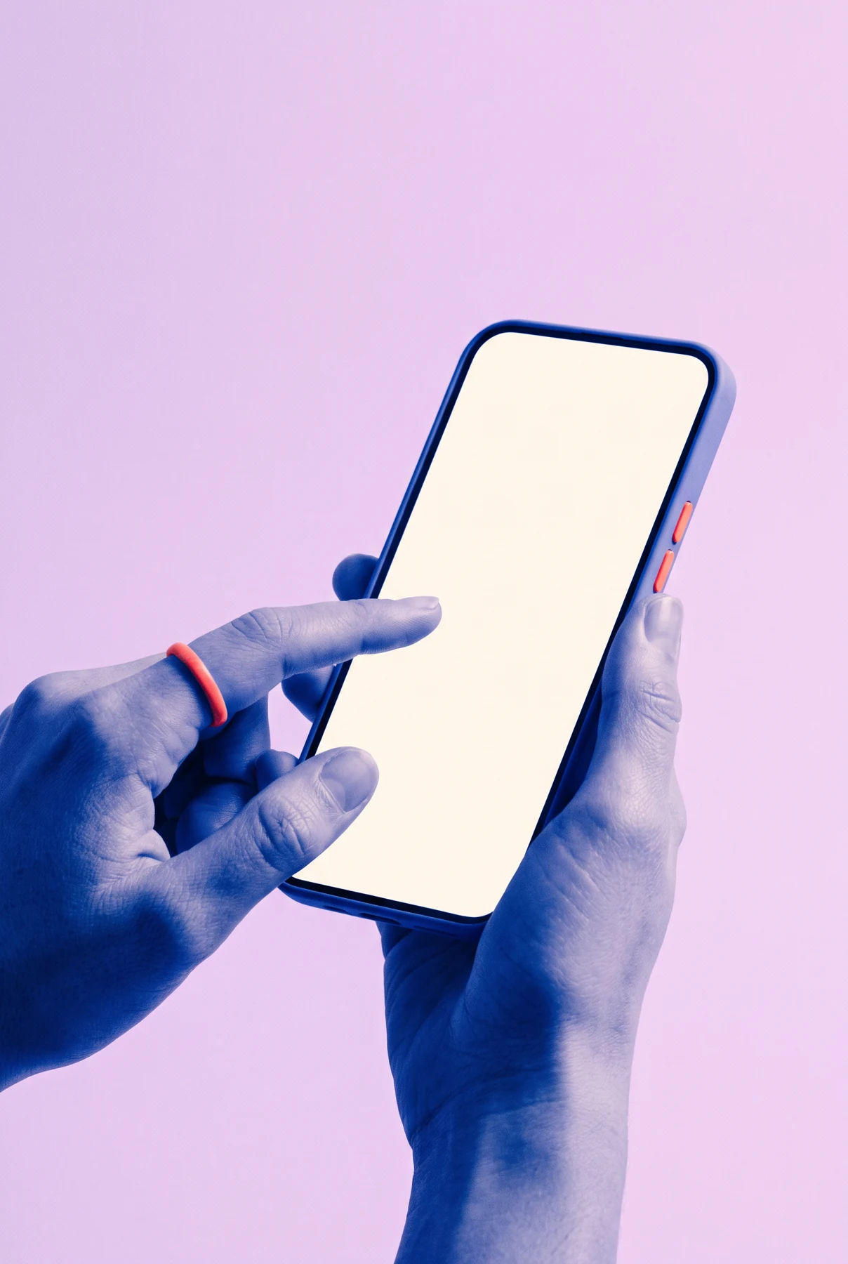 A hand holding a blank smartphone against a lilac background